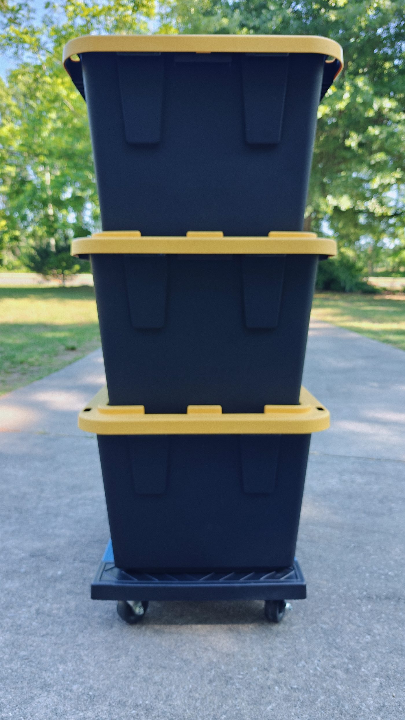 Stack of Smart Fox black and yellow moving totes loaded on a rolling dolly, ready for delivery