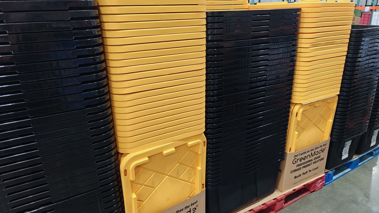 Pallets of black and yellow totes in the warehouse, stocked and ready